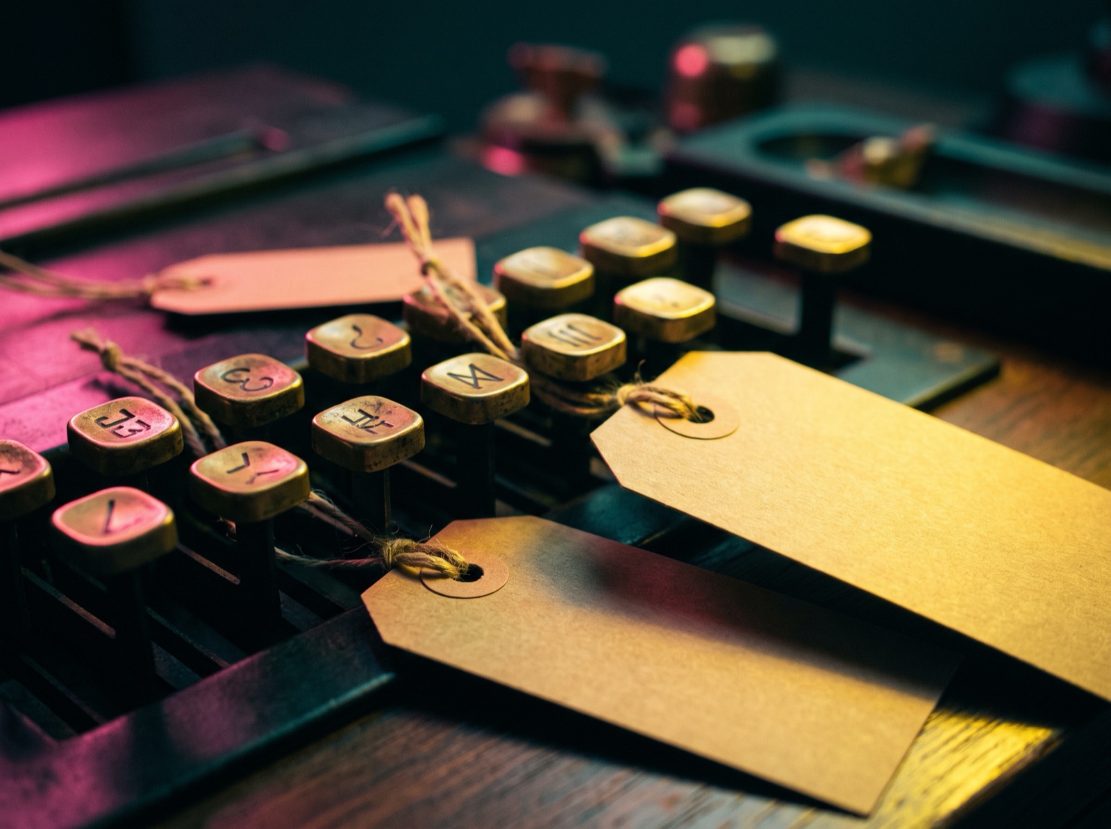 Brass cash register keys and kraft tags under yellow gel light