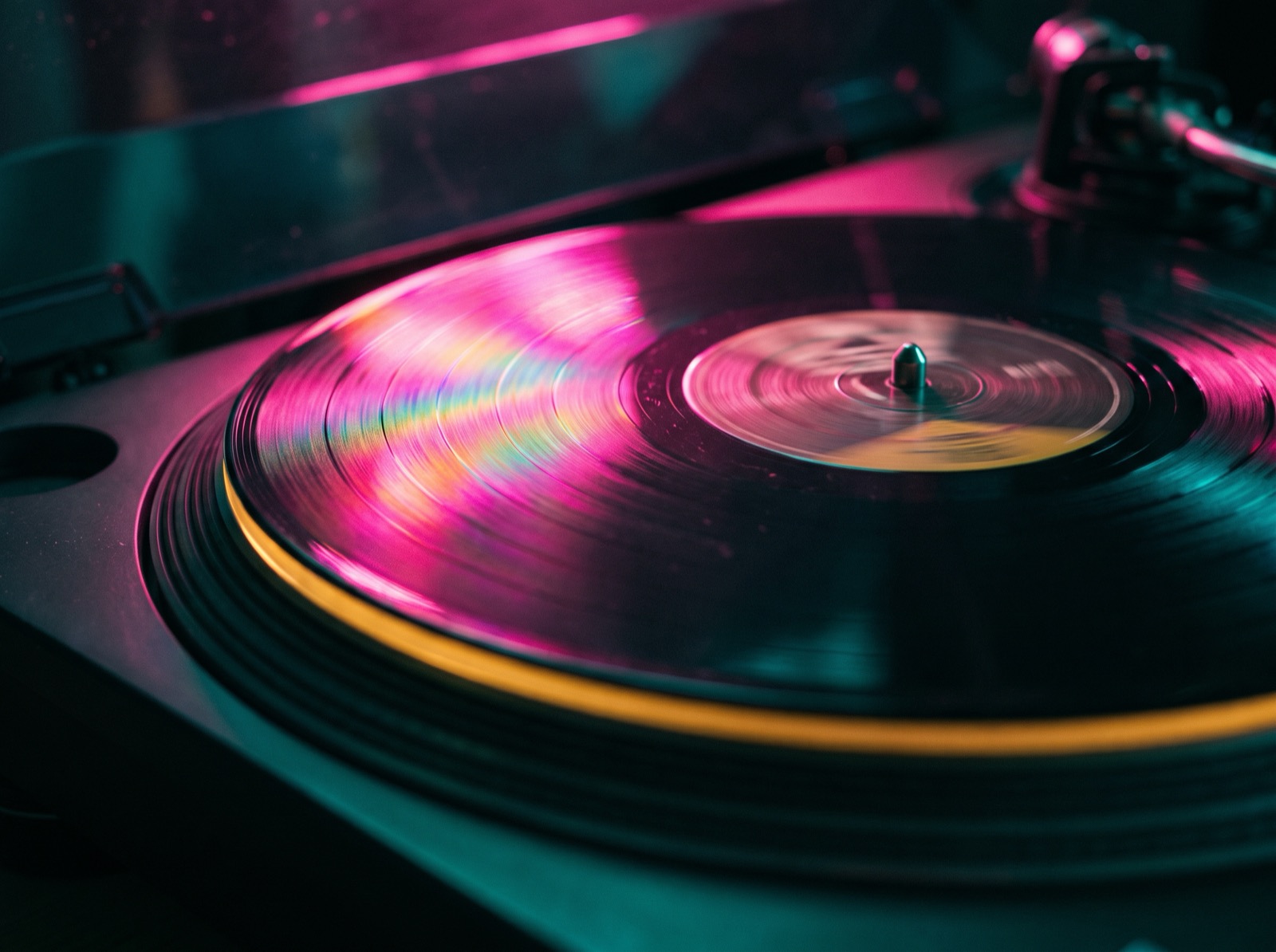 Macro of a vinyl record with pink light raking the grooves