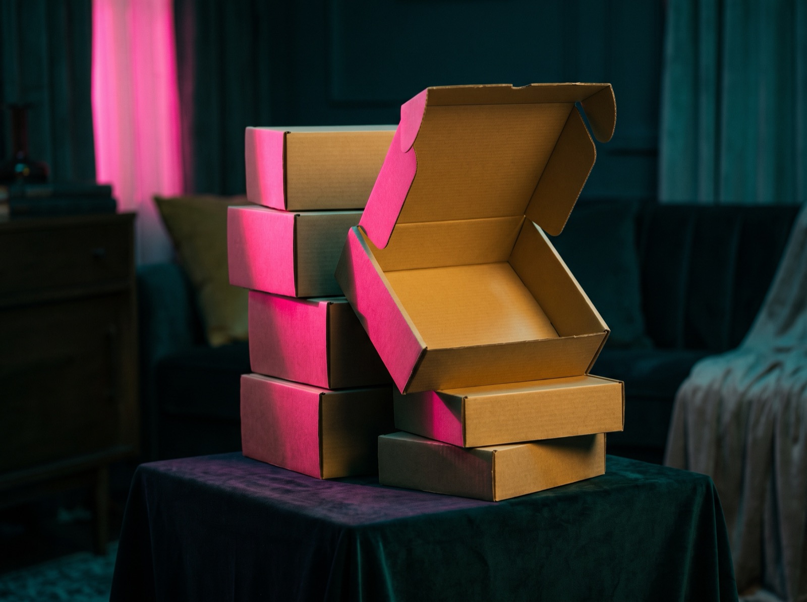 A stack of identical cardboard subscription boxes in teal light